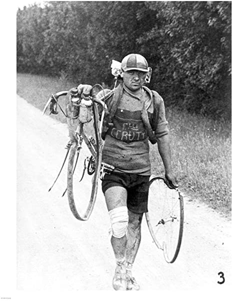 A grumpy cyclist, the Italian Giusto Cerrutti are walking and carrying his broken bicycle during Tour de France 1928 